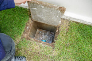 Worker hand open sewer cover of new house